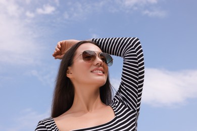 Photo of Beautiful smiling woman wearing stylish sunglasses outdoors