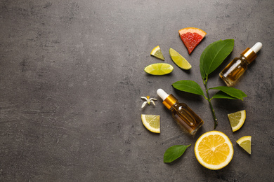 Photo of Flat lay composition with bottles of citrus essential oil on grey background. Space for text