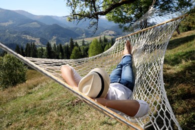 Photo of Young man resting in hammock outdoors on sunny day