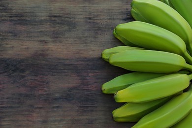 Bunch of delicious bananas on wooden table, top view. Space for text