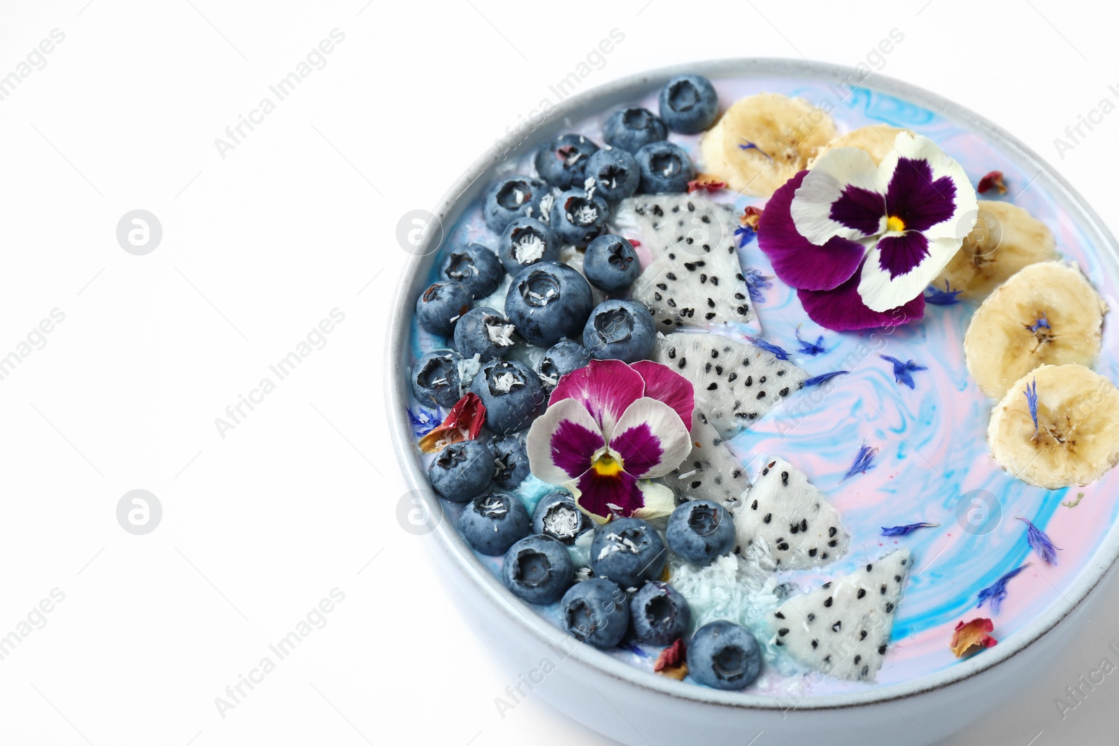 Photo of Delicious smoothie bowl with fresh fruits, blueberries and flowers on white background, closeup. Space for text