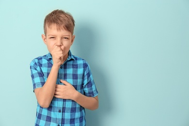 Photo of Little boy coughing on color background