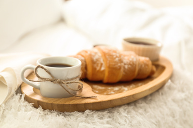 Photo of Delicious morning coffee and croissant on bed