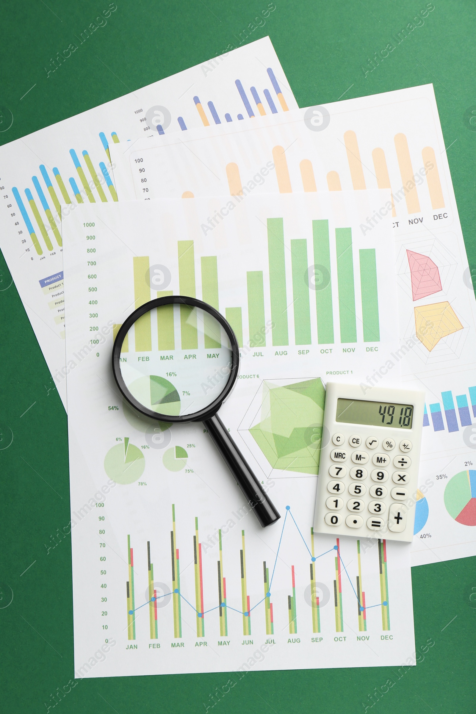 Photo of Accounting documents, magnifying glass and calculator on green background, top view