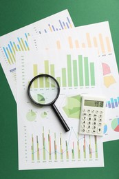 Photo of Accounting documents, magnifying glass and calculator on green background, top view