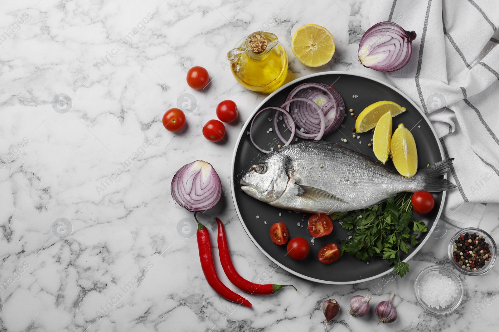 Photo of Fresh dorado fish and ingredients on white marble table, flat lay. Space for text