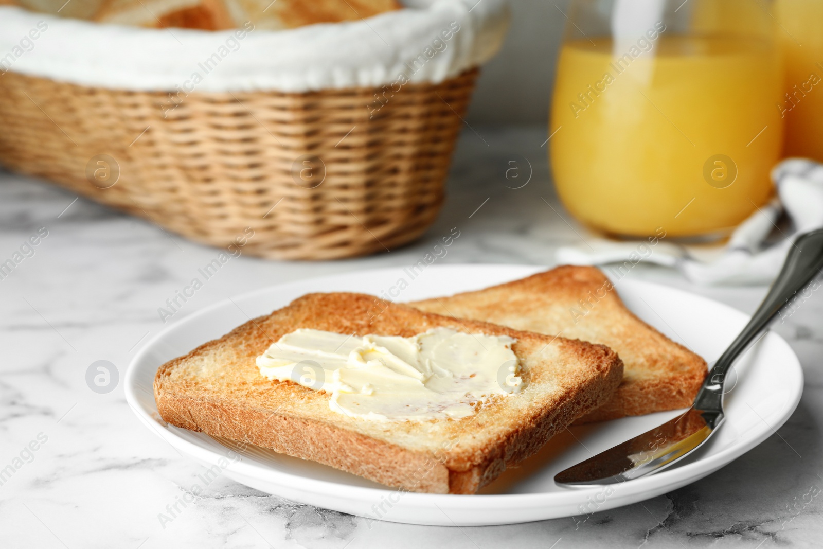 Photo of Slices of toasted bread with butter on white marble table