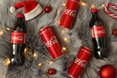 MYKOLAIV, UKRAINE - January 01, 2021: Flat lay composition with Coca-Cola drinks and Christmas decorations on fur background