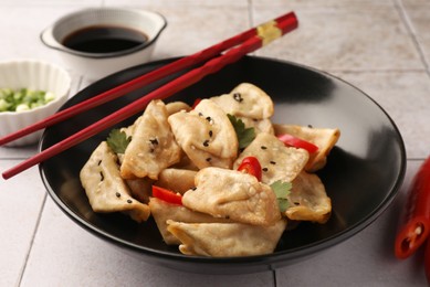 Photo of Delicious gyoza (asian dumplings) and chopsticks on table