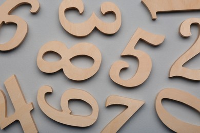 Photo of Wooden numbers on light grey background, flat lay