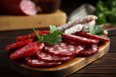 Different types of sausages served on wooden table, closeup