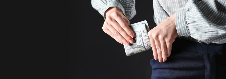 Image of Man putting bribe into pocket on black background, closeup with space for text. Banner design