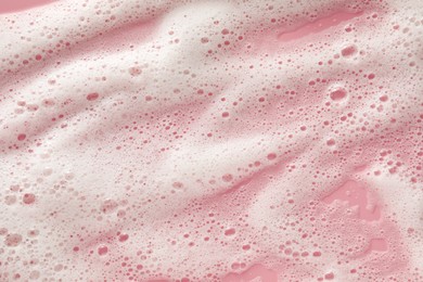 Photo of White washing foam on pale pink background, top view