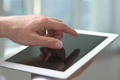 Closeup view of man using new tablet indoors