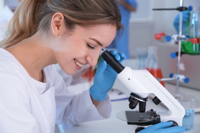 Photo of Medical student working with microscope in modern scientific laboratory