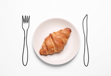 Plate with crispy croissant and drawn cutlery on white background, top view