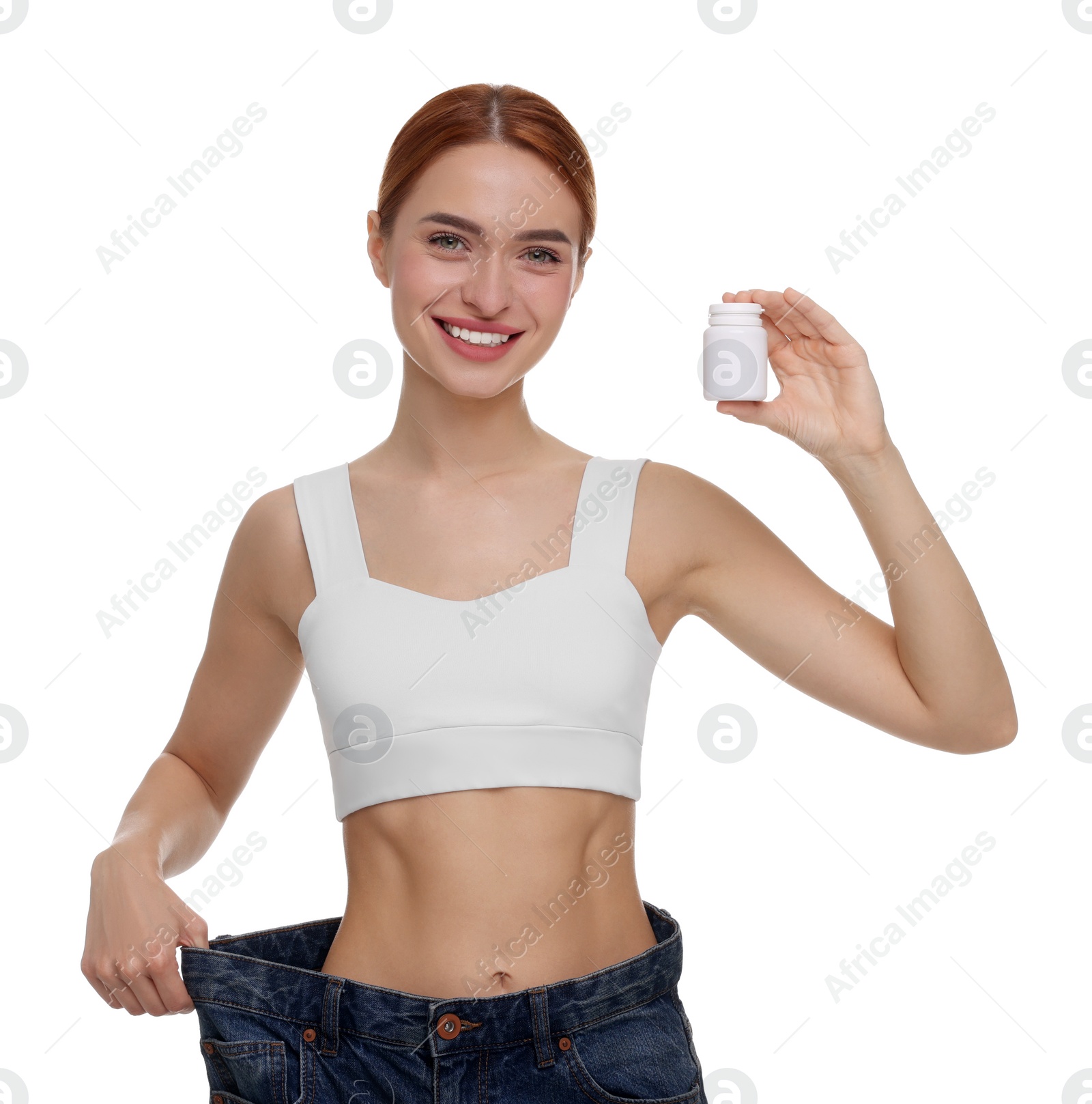 Photo of Slim woman in big jeans with bottle of pills on white background. Weight loss