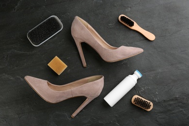 Photo of Stylish footwear with shoe care accessories on black table, flat lay