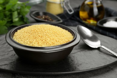 Photo of Raw couscous and ingredients on grey table, closeup