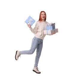 Young woman in sweater with Christmas gifts on white background