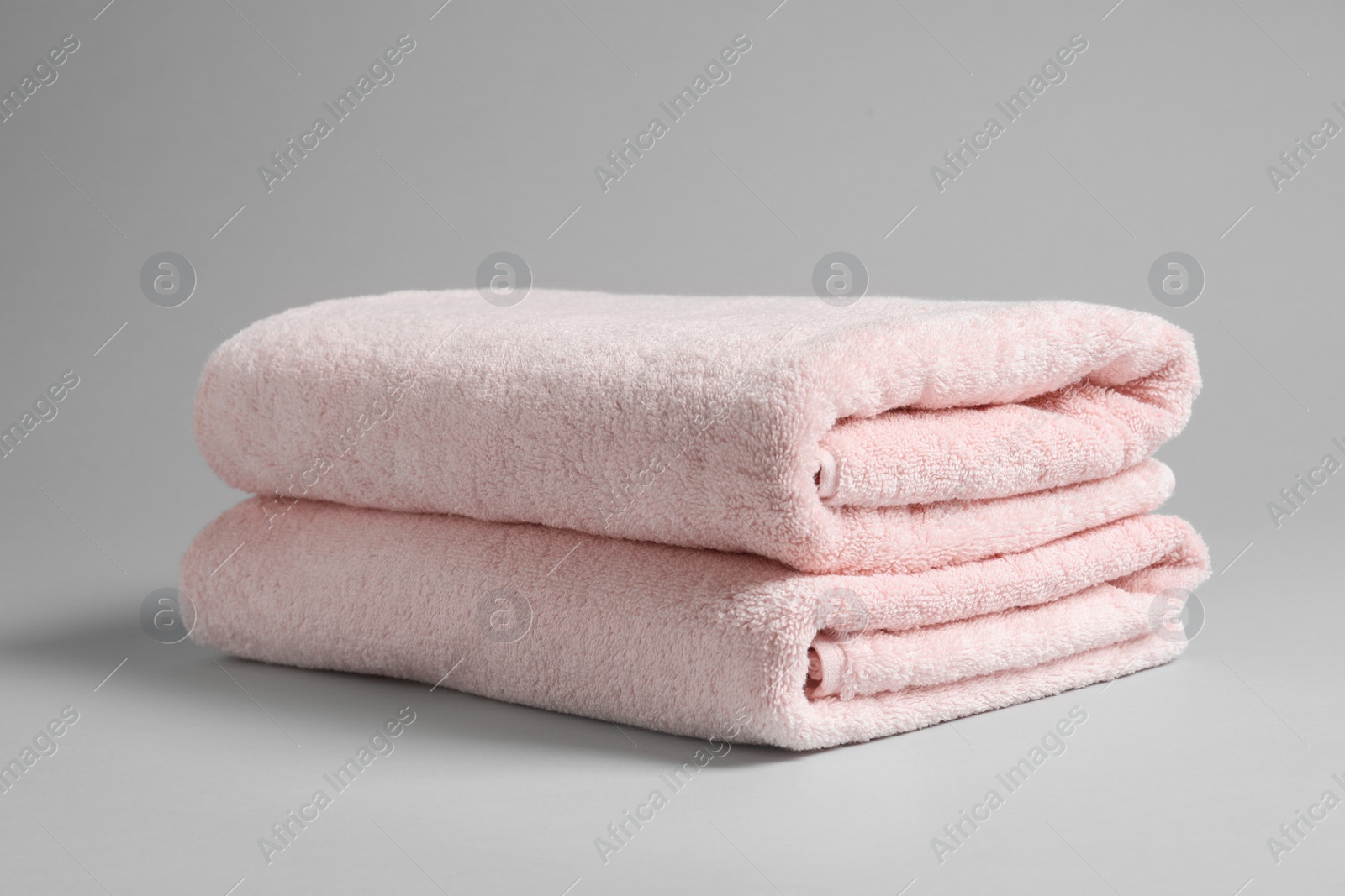 Photo of Fresh soft folded towels on light background