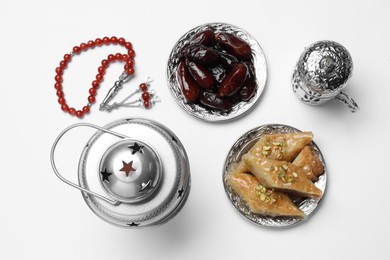 Composition with Arabic lantern and snacks on white background, top view