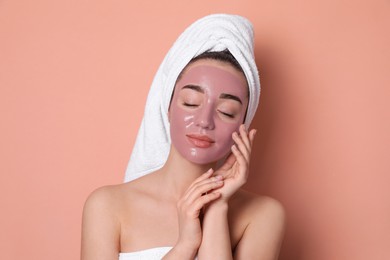 Woman with pomegranate face mask on pale coral background