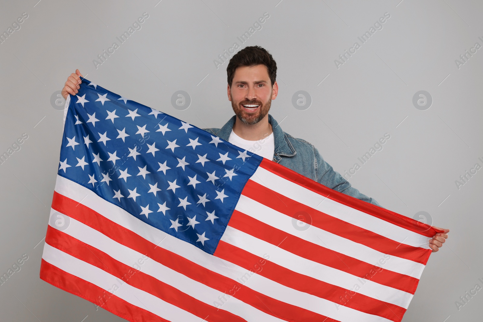 Photo of 4th of July - Independence Day of USA. Happy man with American flag on grey background