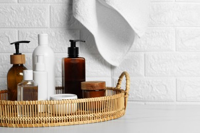 Photo of Different bath accessories and personal care products on white table near brick wall, space for text