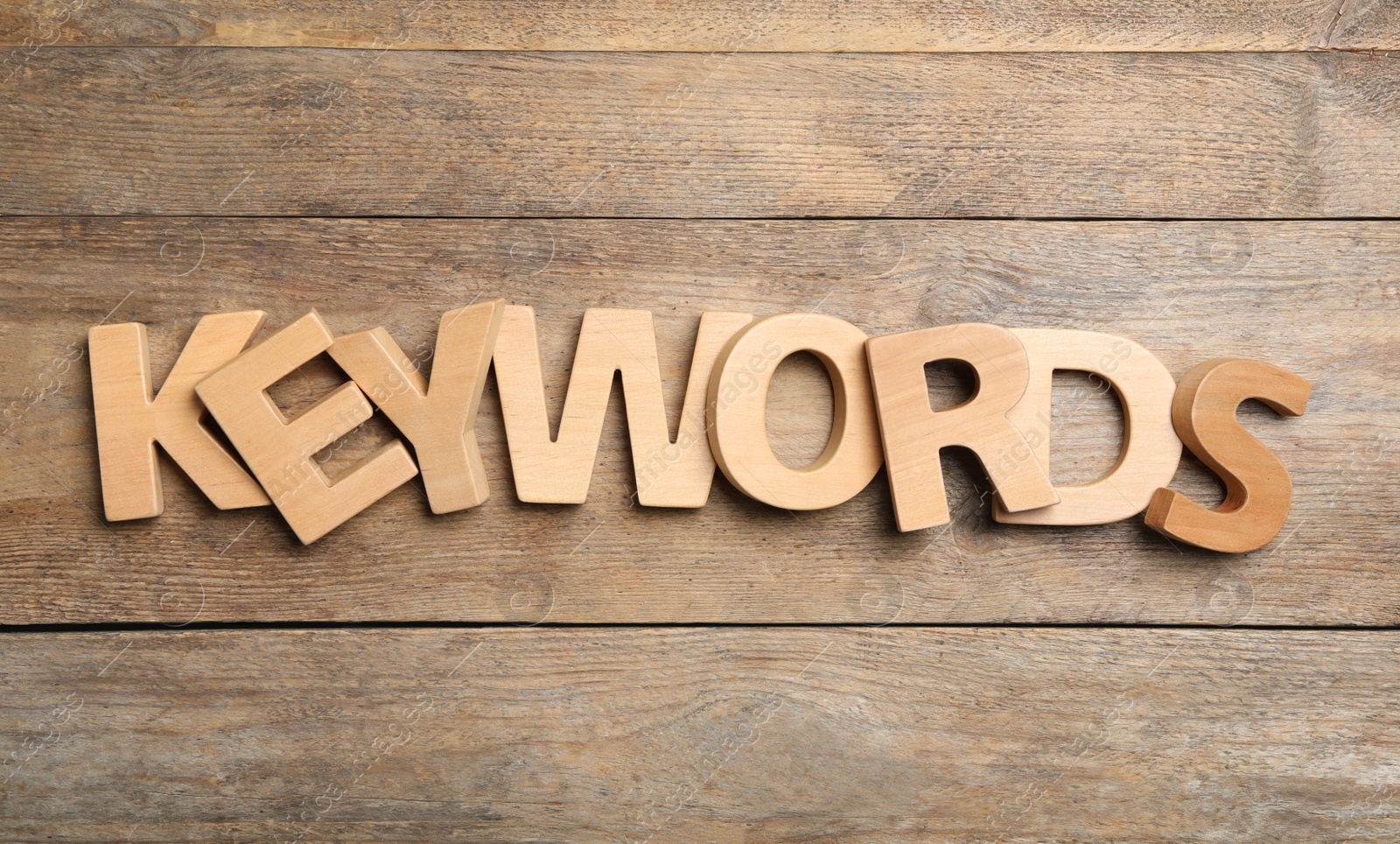 Photo of Word KEYWORDS made of letters on wooden background, flat lay