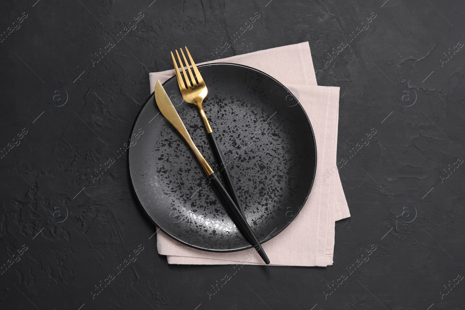 Photo of Elegant setting with shiny cutlery on black table, top view