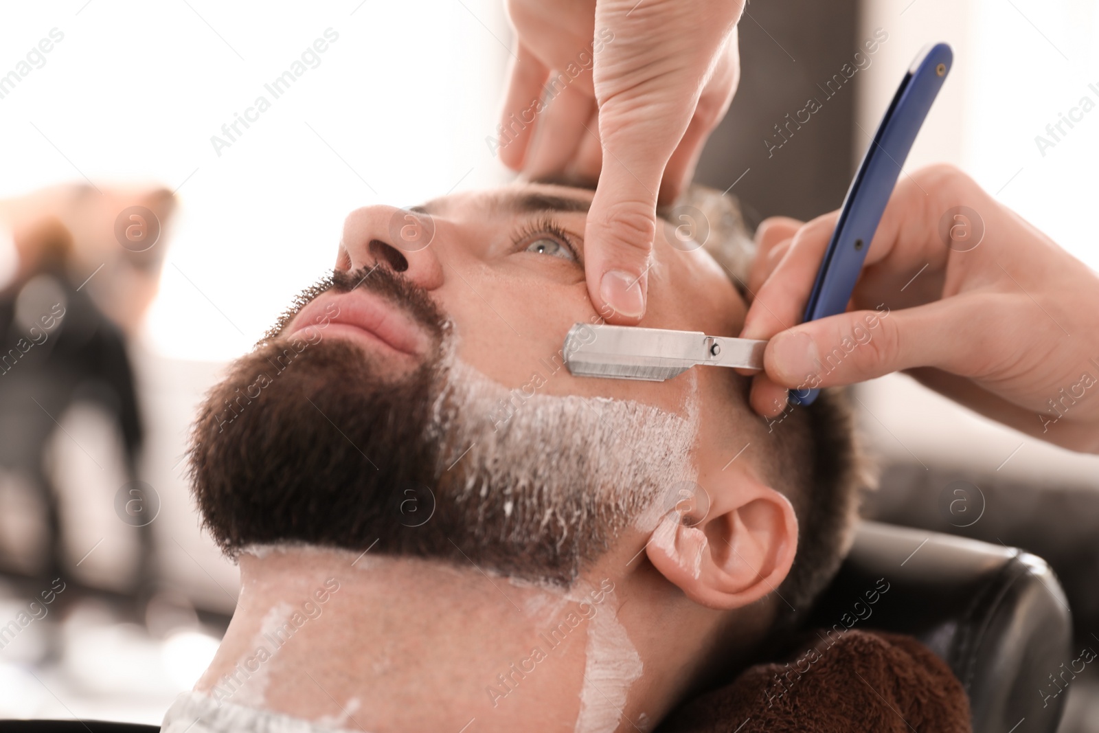 Photo of Professional barber working with client in hairdressing salon. Hipster fashion