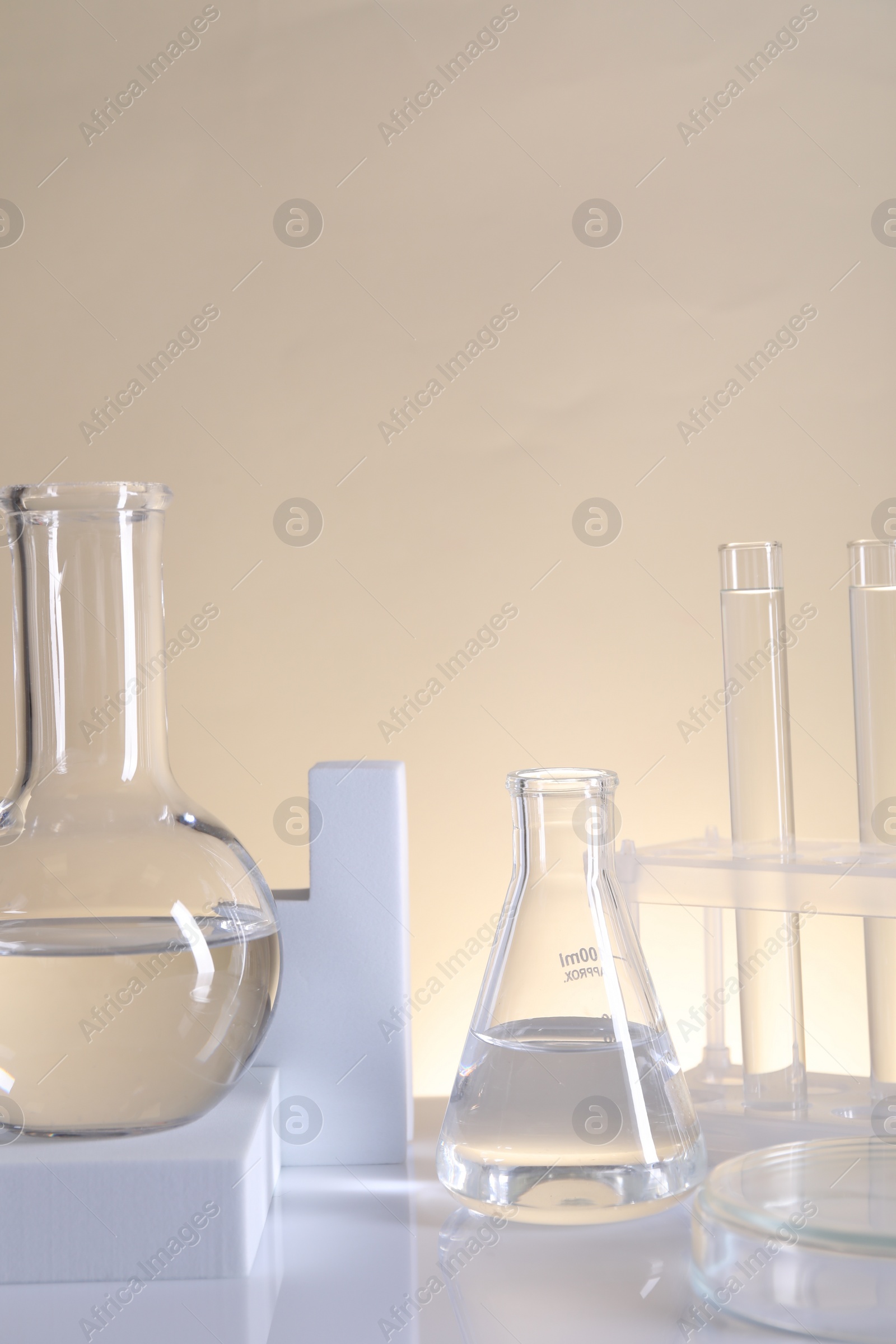 Photo of Laboratory analysis. Different glassware on table against beige background