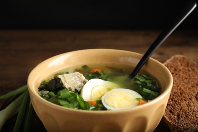 Delicious sorrel soup with meat and eggs in bowl, closeup
