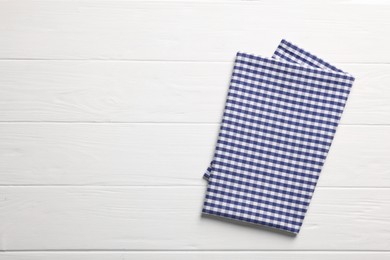 Photo of Blue checkered tablecloth on wooden table, top view. Space for text