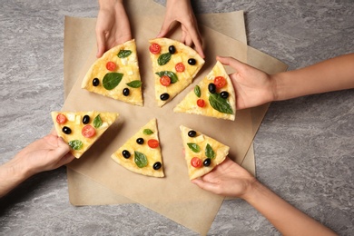 Photo of People taking tasty homemade pizza slices from table, top view