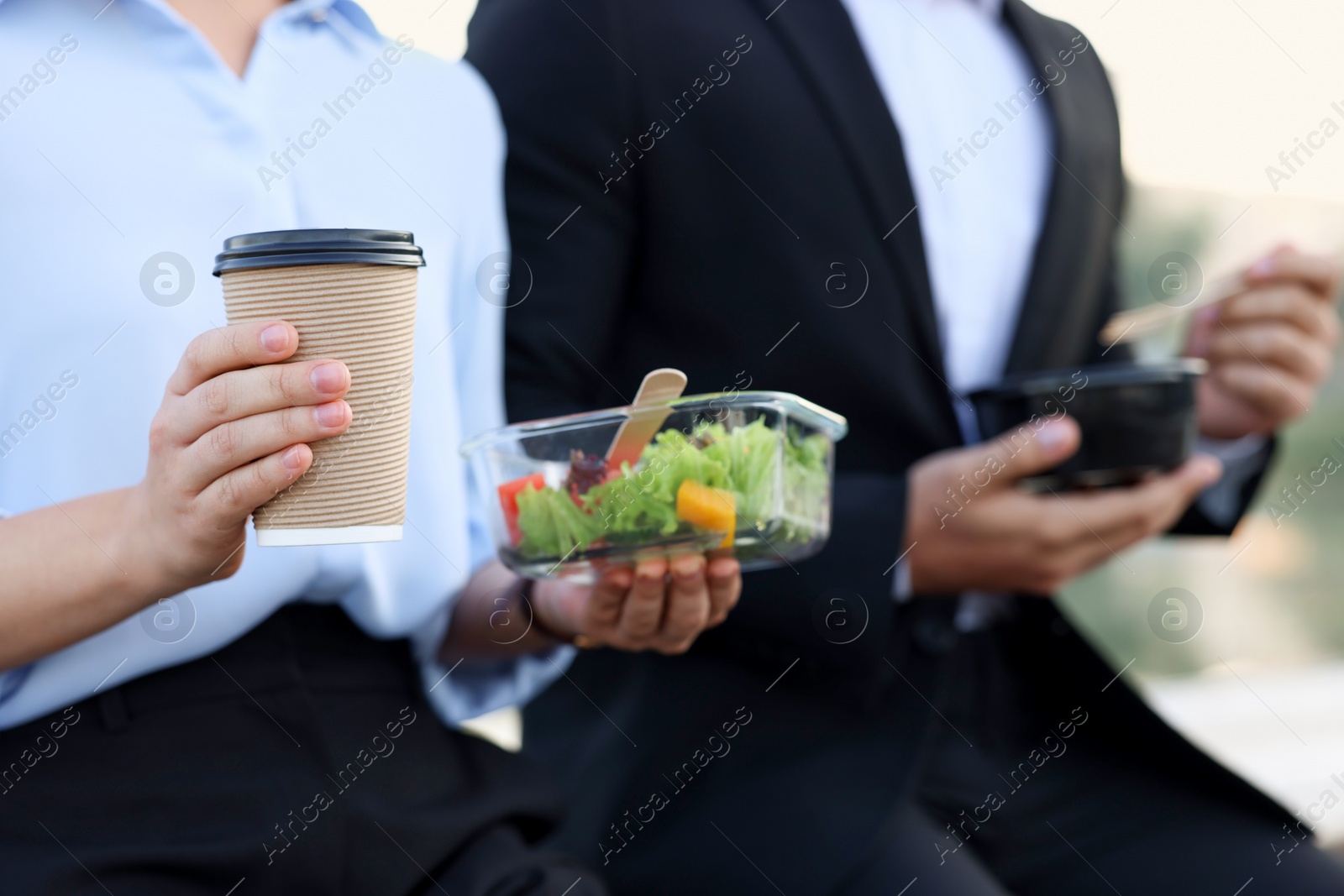 Photo of Business people having lunch together outdoors, closeup