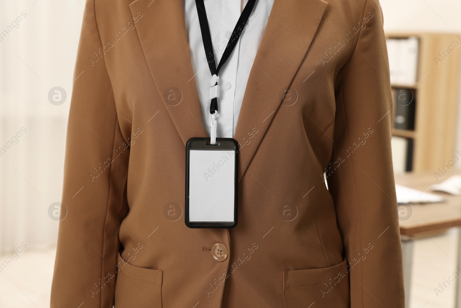 Photo of Woman with blank badge indoors, closeup view