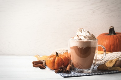 Photo of Delicious pumpkin latte on white table. Space for text