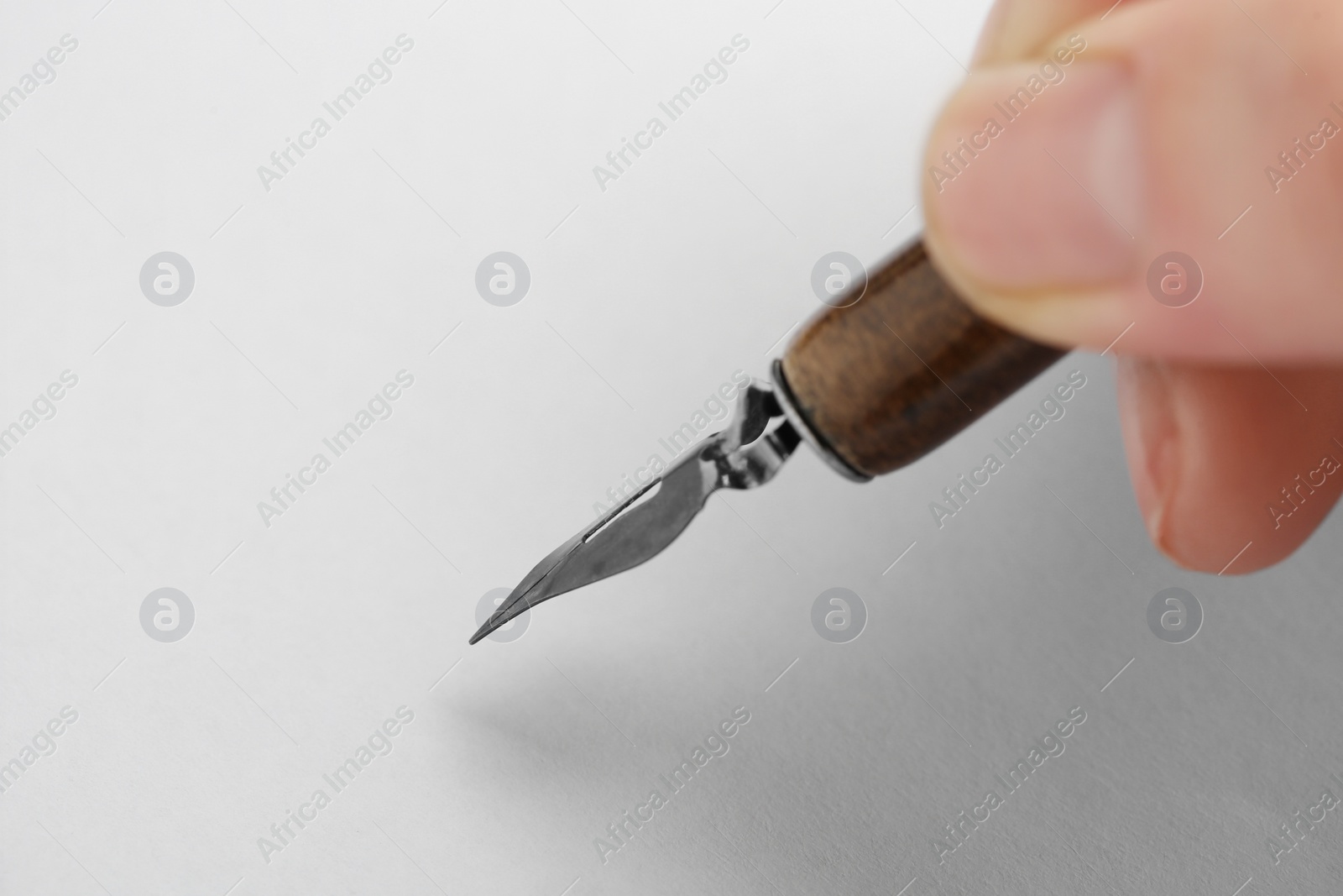 Photo of Woman with fountain pen above white paper, closeup