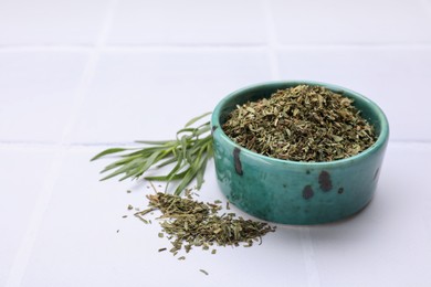 Photo of Dry and fresh tarragon on white tiled table, space for text