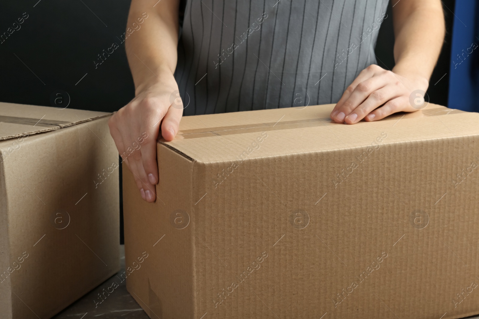 Photo of Woman packing box at table, closeup. Space for design