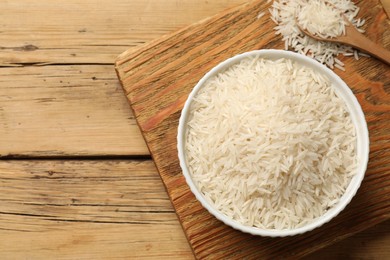Photo of Raw basmati rice on wooden table. flat lay. Space for text