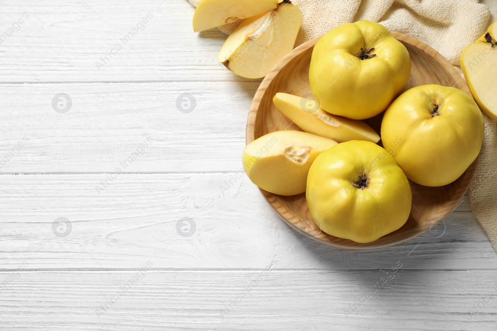 Photo of Fresh ripe organic quinces on white wooden table, flat lay. Space for text