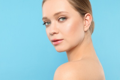 Portrait of young woman with beautiful face on blue background, closeup. Space for text