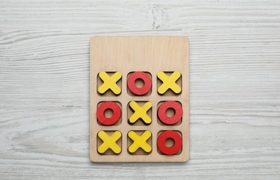 Photo of Tic tac toe set on white wooden table, top view