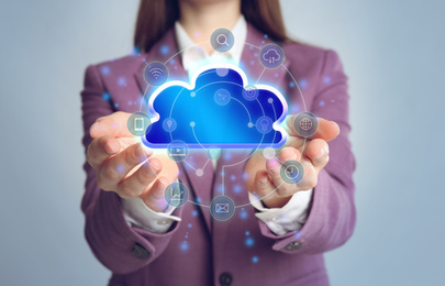 Image of Young woman demonstrating digital cloud with icons on grey background, closeup. Modern technology