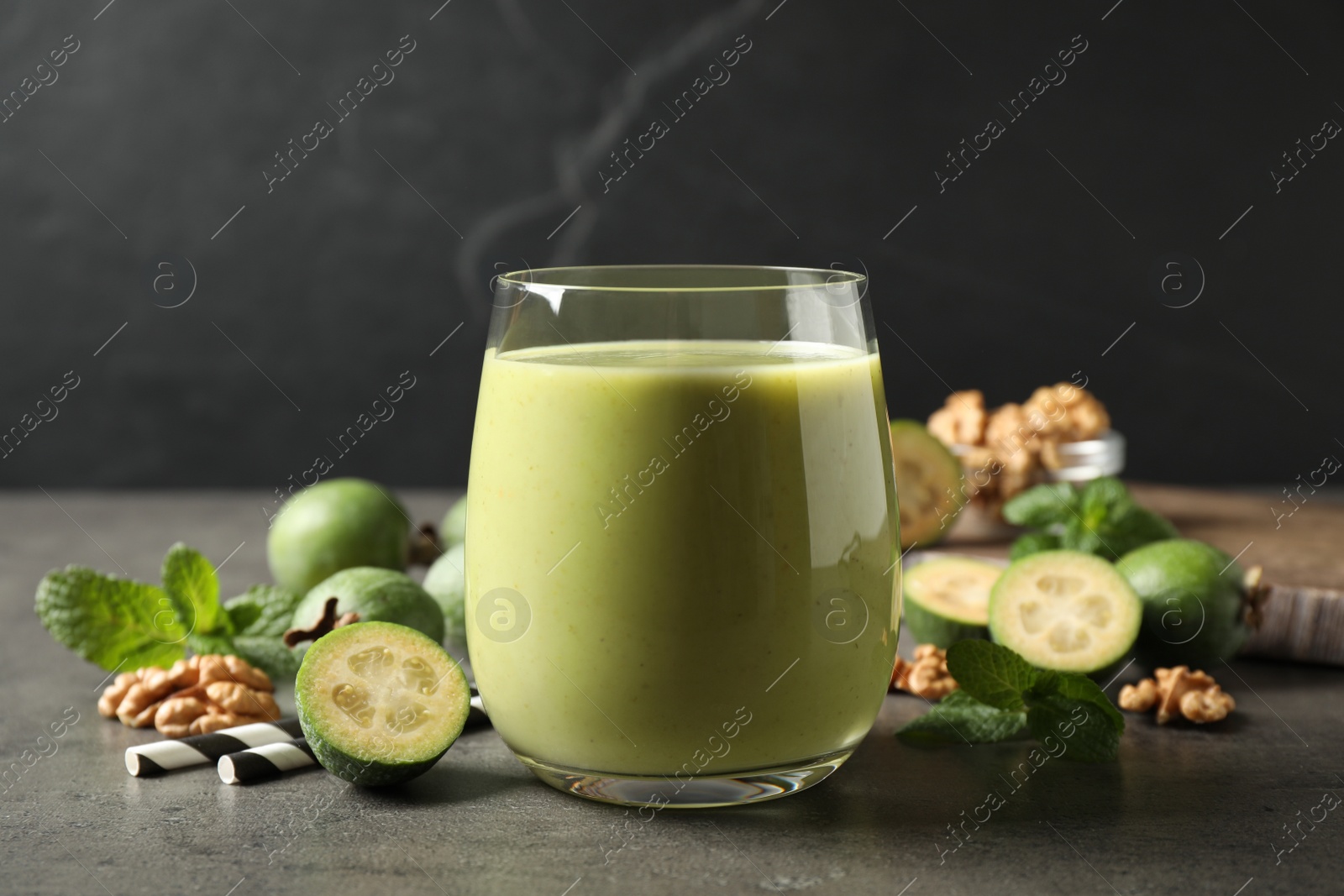 Photo of Fresh feijoa smoothie in glass on grey table