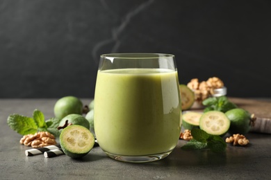 Fresh feijoa smoothie in glass on grey table