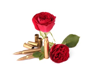 Photo of Bullets and cartridge cases with beautiful rose flowers isolated on white